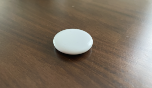 Apple AirTag 2 product shot on a wooden table